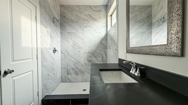 full bath with vanity and tiled shower