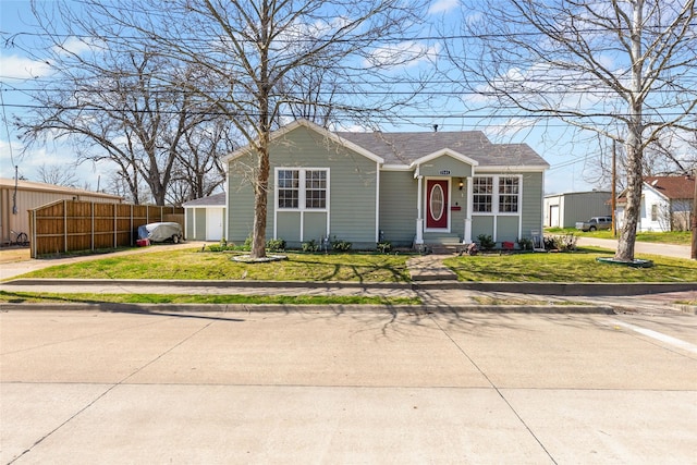 view of front of house with entry steps, a front yard, and fence