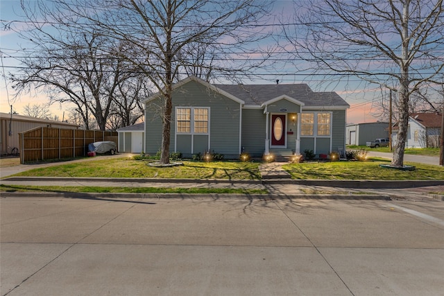 view of front of house with a lawn, a garage, and fence