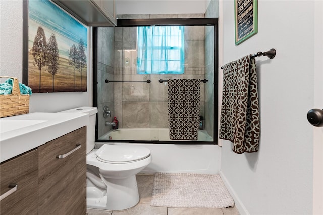 bathroom with vanity, baseboards, enclosed tub / shower combo, tile patterned flooring, and toilet