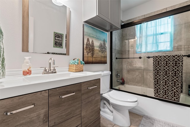 bathroom featuring vanity, tile patterned floors, toilet, and combined bath / shower with glass door