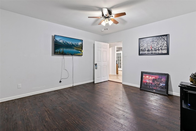 unfurnished living room featuring baseboards, wood finished floors, and a ceiling fan