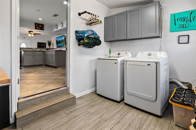 laundry area featuring light wood finished floors, visible vents, cabinet space, independent washer and dryer, and a ceiling fan