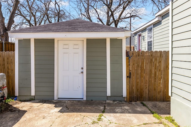 view of outdoor structure featuring an outbuilding and fence