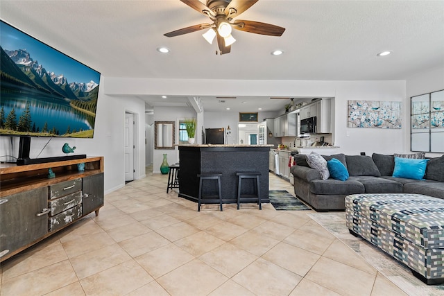 living room with light tile patterned floors, recessed lighting, a textured ceiling, and ceiling fan