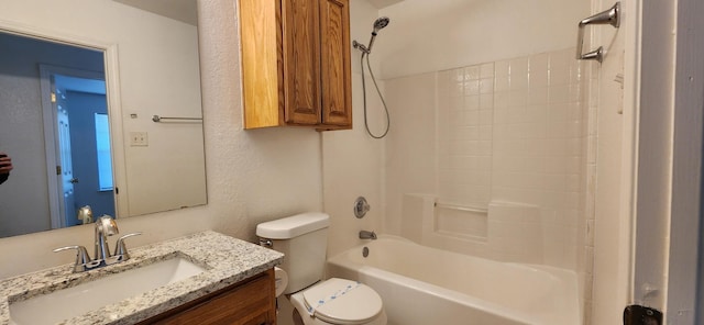 full bathroom with vanity, toilet, a textured wall, and bathtub / shower combination