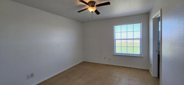 empty room featuring light tile patterned floors, baseboards, and a ceiling fan