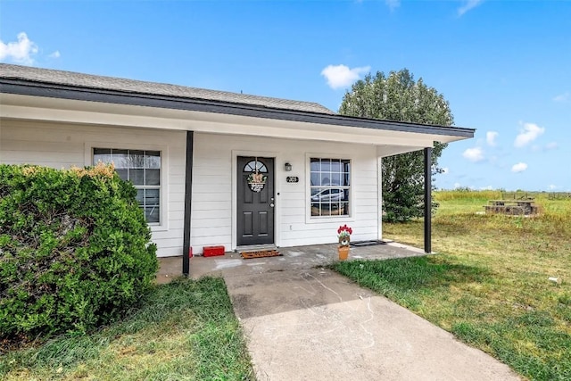 entrance to property with a yard and a porch