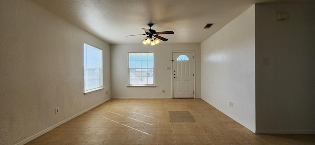 foyer entrance with light tile patterned floors, visible vents, baseboards, and ceiling fan