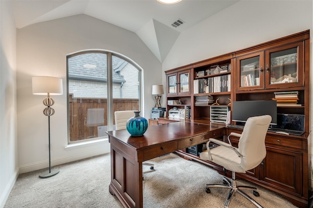 office space featuring lofted ceiling, baseboards, visible vents, and light carpet