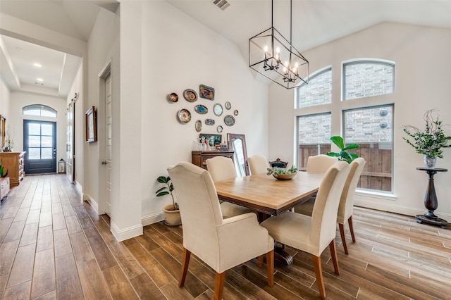 dining area featuring a notable chandelier, baseboards, and wood finish floors