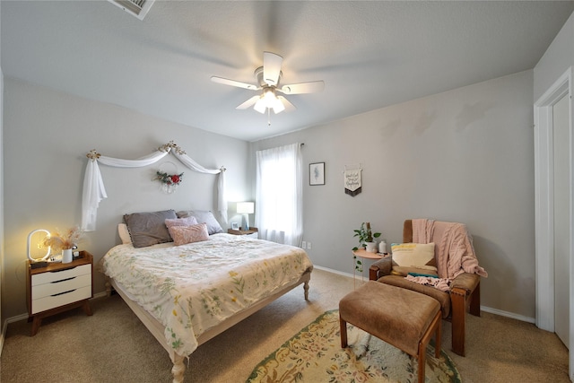 bedroom with baseboards, light carpet, visible vents, and ceiling fan