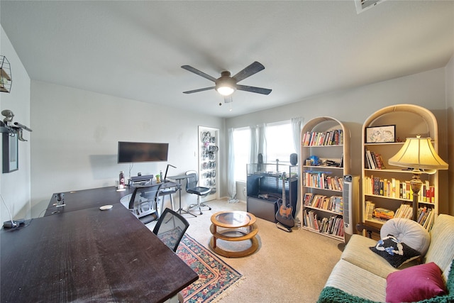 carpeted living area with a ceiling fan