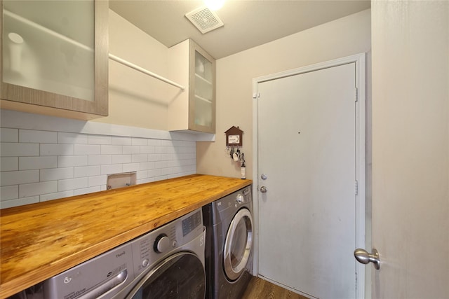 washroom with visible vents, laundry area, and separate washer and dryer