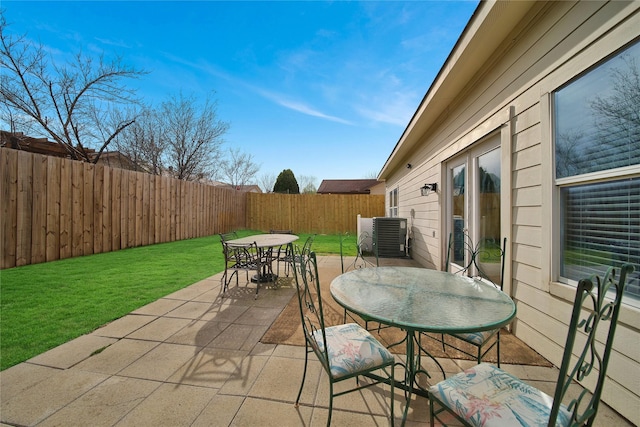 view of patio with central air condition unit, a fenced backyard, and outdoor dining space