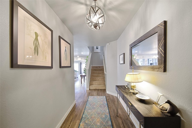 hallway with dark wood-style floors, stairs, and baseboards