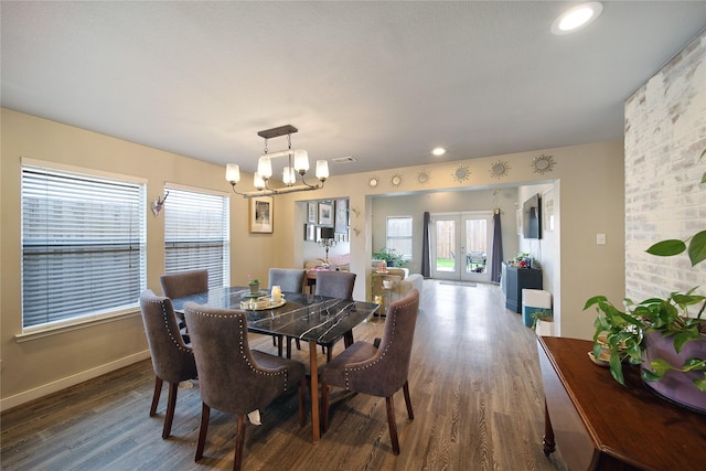 dining space with visible vents, wood finished floors, baseboards, and a chandelier