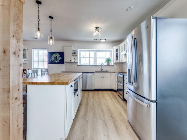 206 Cocopa Dr, Lake Kiowa, TX 76240 - kitchen with stainless steel appliances, wooden counters, a sink, light wood finished floors, and decorative backsplash