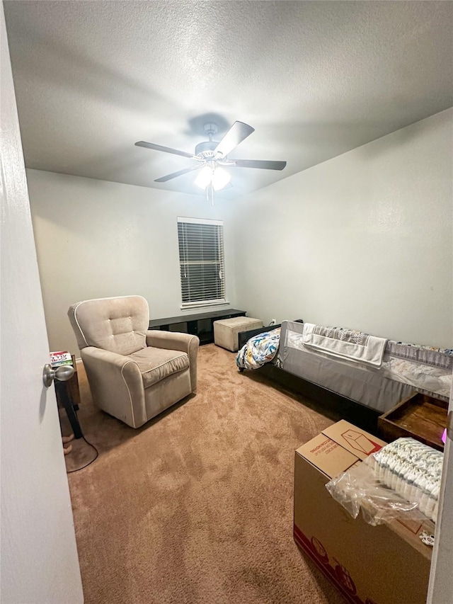 living area featuring a textured ceiling, ceiling fan, and carpet floors