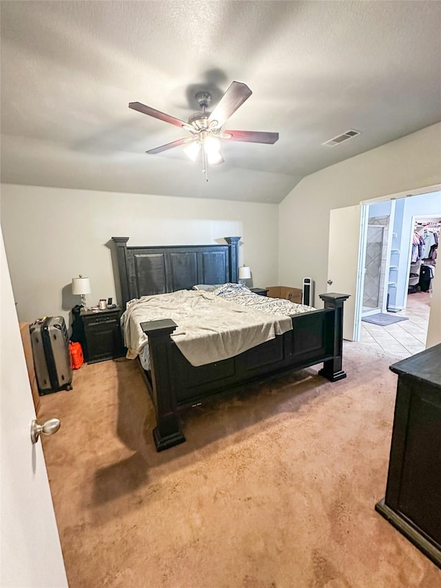 bedroom featuring a ceiling fan, visible vents, vaulted ceiling, a textured ceiling, and light carpet