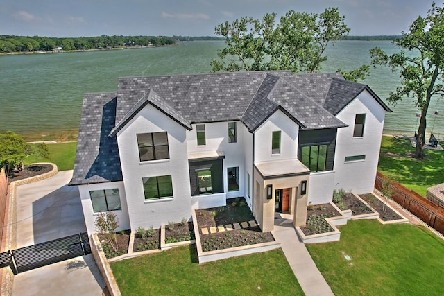 1733 E Lake Dr, Weatherford, TX 76087 - view of front of home featuring fence, a vegetable garden, a shingled roof, a front lawn, and a water view