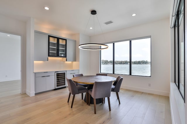 1733 E Lake Dr, Weatherford, TX 76087 - dining room featuring beverage cooler, light wood finished floors, recessed lighting, a water view, and a dry bar