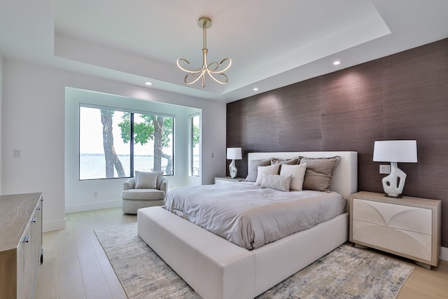 1733 E Lake Dr, Weatherford, TX 76087 - bedroom featuring baseboards, a raised ceiling, a notable chandelier, and an accent wall