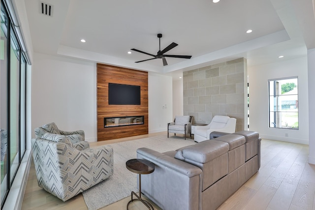 1733 E Lake Dr, Weatherford, TX 76087 - living area with light wood finished floors, visible vents, a large fireplace, an accent wall, and a tray ceiling