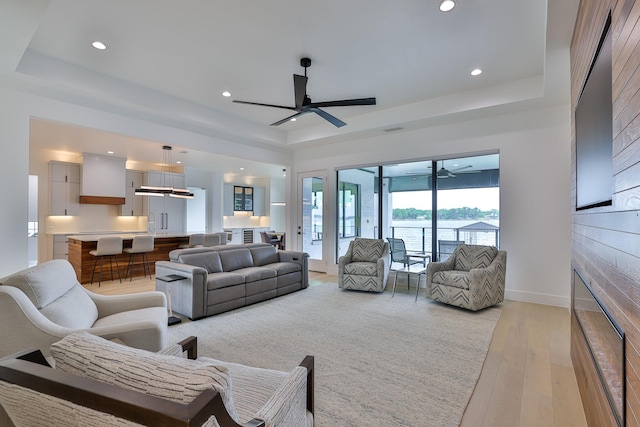 1733 E Lake Dr, Weatherford, TX 76087 - living room with light wood finished floors, ceiling fan, baseboards, and a tray ceiling