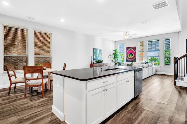 kitchen featuring dishwasher, a sink, visible vents, and dark countertops
