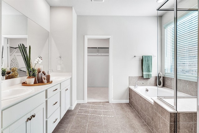 bathroom featuring a sink, a garden tub, and a healthy amount of sunlight