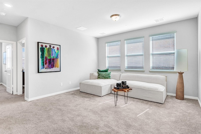 living area with baseboards, visible vents, and carpet floors