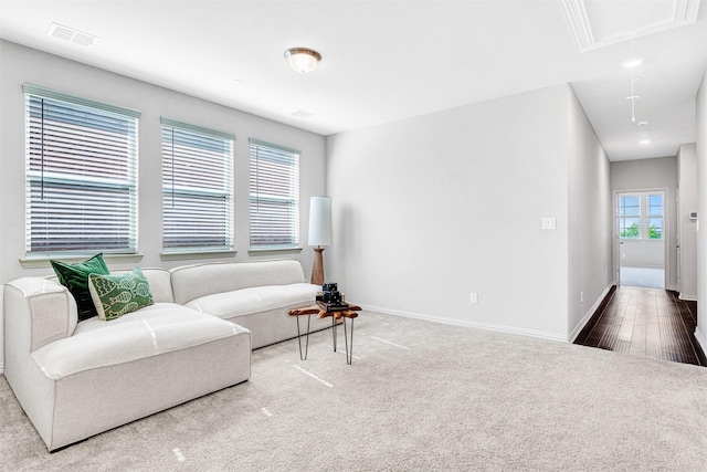 living area featuring attic access, baseboards, carpet flooring, and visible vents