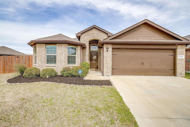 ranch-style house featuring brick siding, an attached garage, concrete driveway, and fence