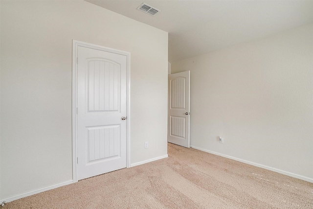 unfurnished bedroom with light carpet, visible vents, and baseboards