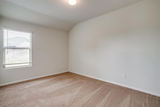 carpeted empty room with baseboards and lofted ceiling