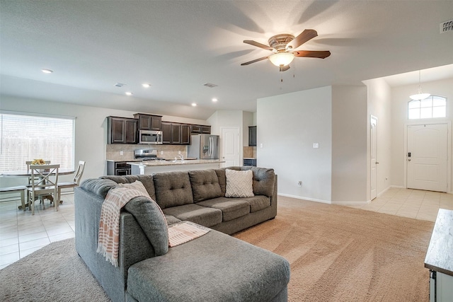 living area with visible vents, light tile patterned flooring, a ceiling fan, and light colored carpet