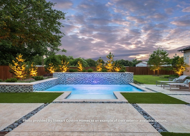 pool at dusk with a patio area, a yard, a fenced backyard, and a fenced in pool