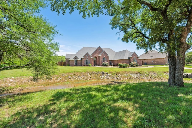 view of front of home featuring brick siding and a front yard