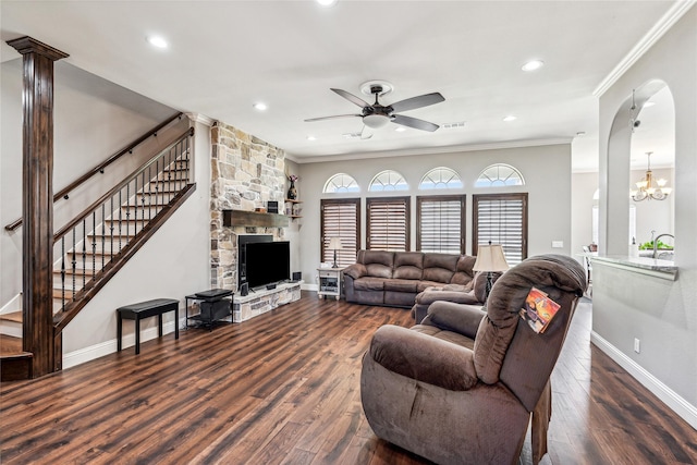 living area featuring ceiling fan with notable chandelier, ornamental molding, and wood finished floors