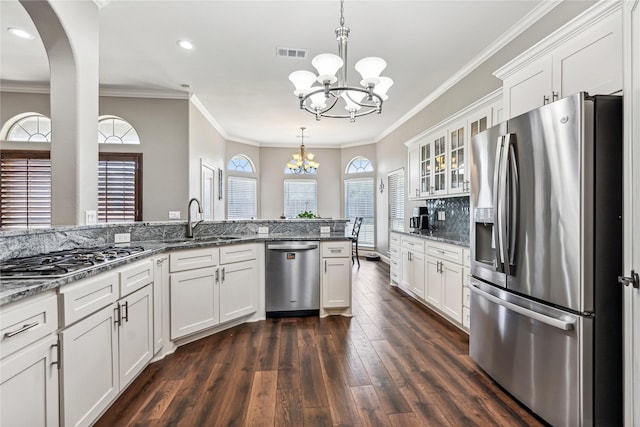 kitchen with visible vents, a sink, stainless steel appliances, white cabinets, and a chandelier