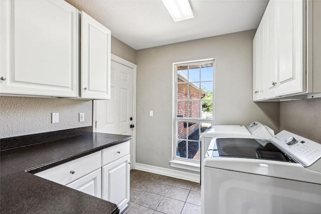 washroom with cabinet space, light tile patterned floors, washing machine and dryer, and baseboards