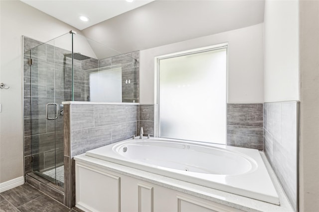 bathroom featuring recessed lighting, a bath, a shower stall, and vaulted ceiling