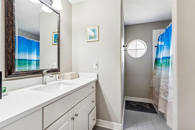 bathroom featuring vanity, shower / tub combo with curtain, and baseboards