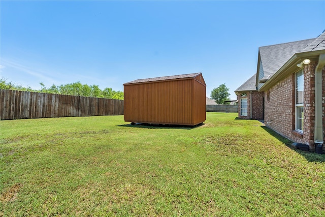 view of yard with an outdoor structure, a storage shed, and a fenced backyard