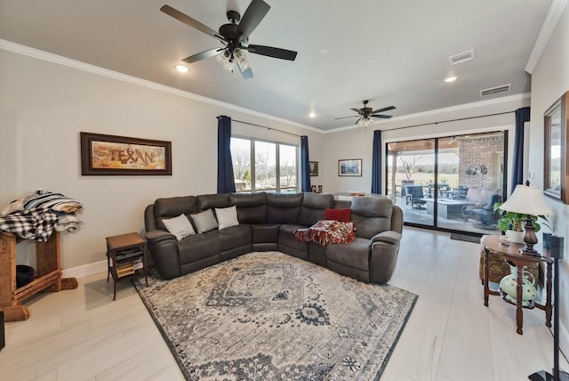 living area featuring visible vents, plenty of natural light, a ceiling fan, and crown molding