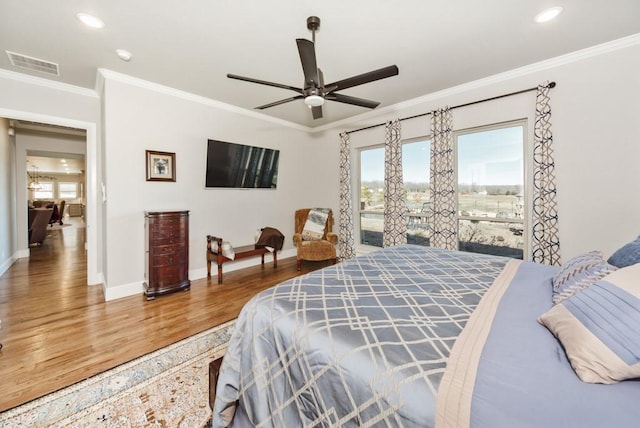 bedroom with visible vents, crown molding, baseboards, recessed lighting, and wood finished floors