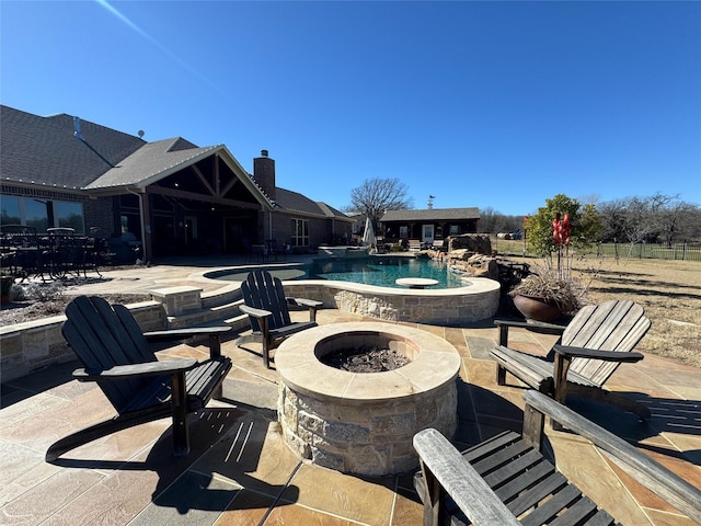 outdoor pool with a patio, an in ground hot tub, and an outdoor fire pit