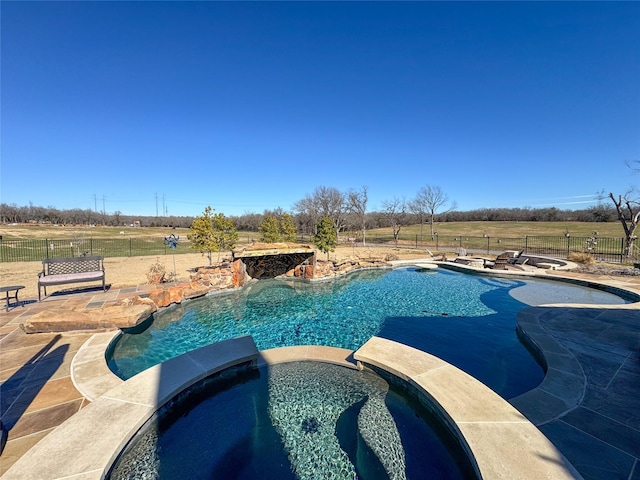 view of swimming pool featuring a patio, fence, and a pool with connected hot tub