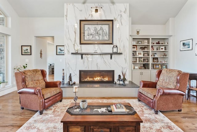 living area featuring wood finished floors and a high end fireplace